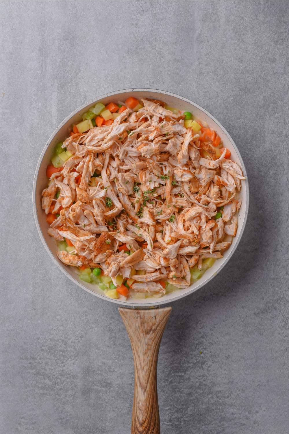 A frying pan with the veggies and chicken added.