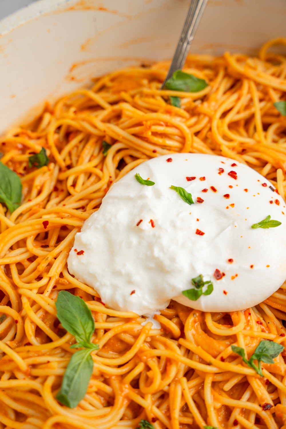 Burrata spaghetti garnished with fresh basil.